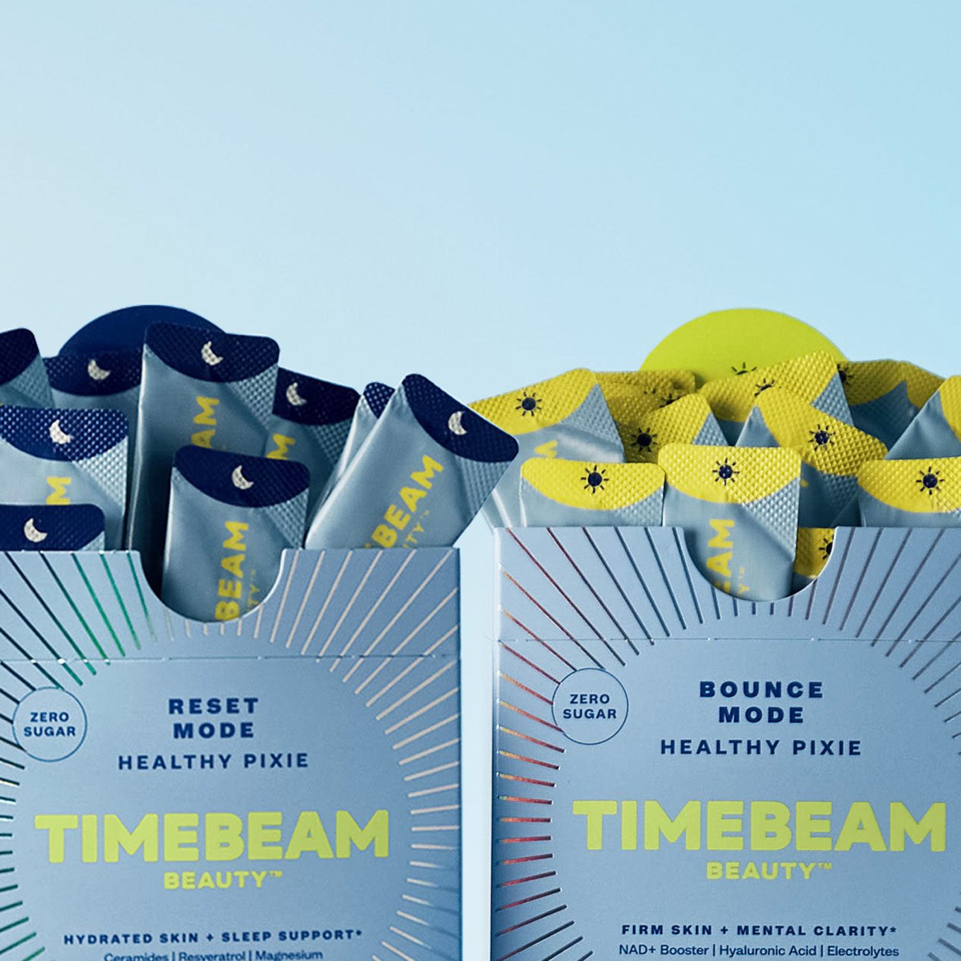 Two boxes of 'TIMEBEAM Beauty' supplements, one labeled 'Bounce Mode Healthy Pixie' with yellow and blue packaging, and the other 'Reset Mode Healthy Pixie'
