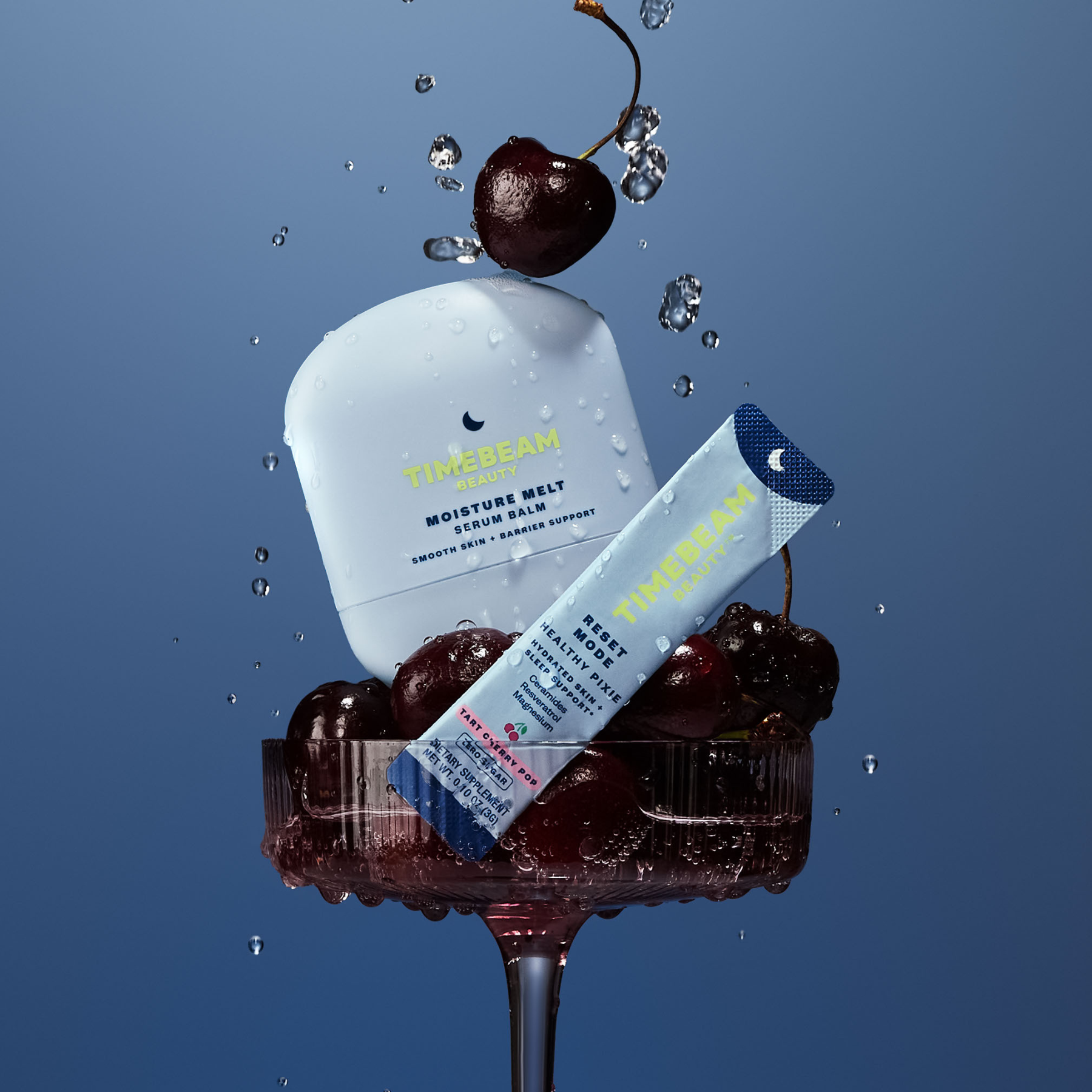 Moisture Melt & Reset Mode skincare products with cherries on a blue background