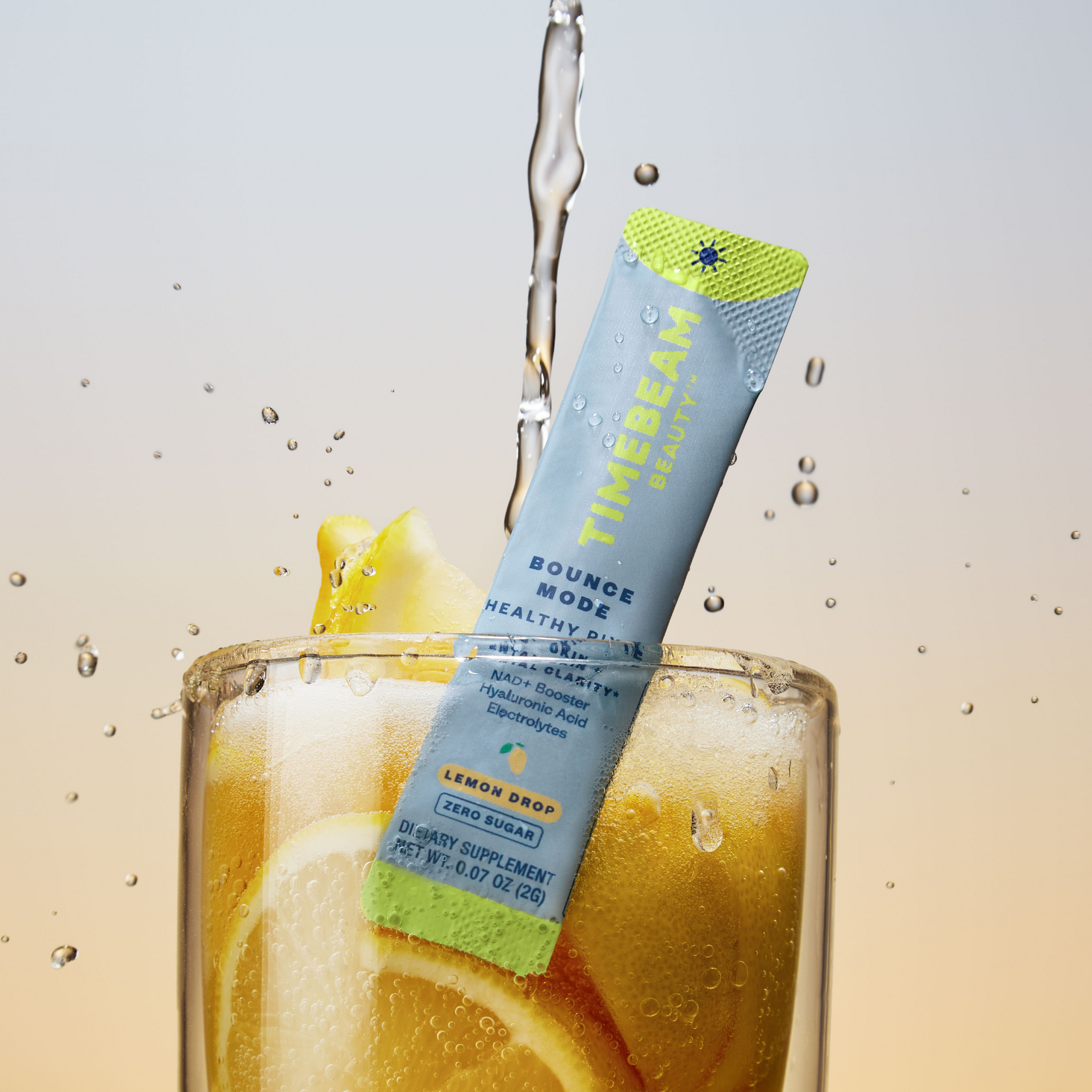A TIMEBEAM supplement pouch in a glass filled with lemon slices, being drizzled in water.