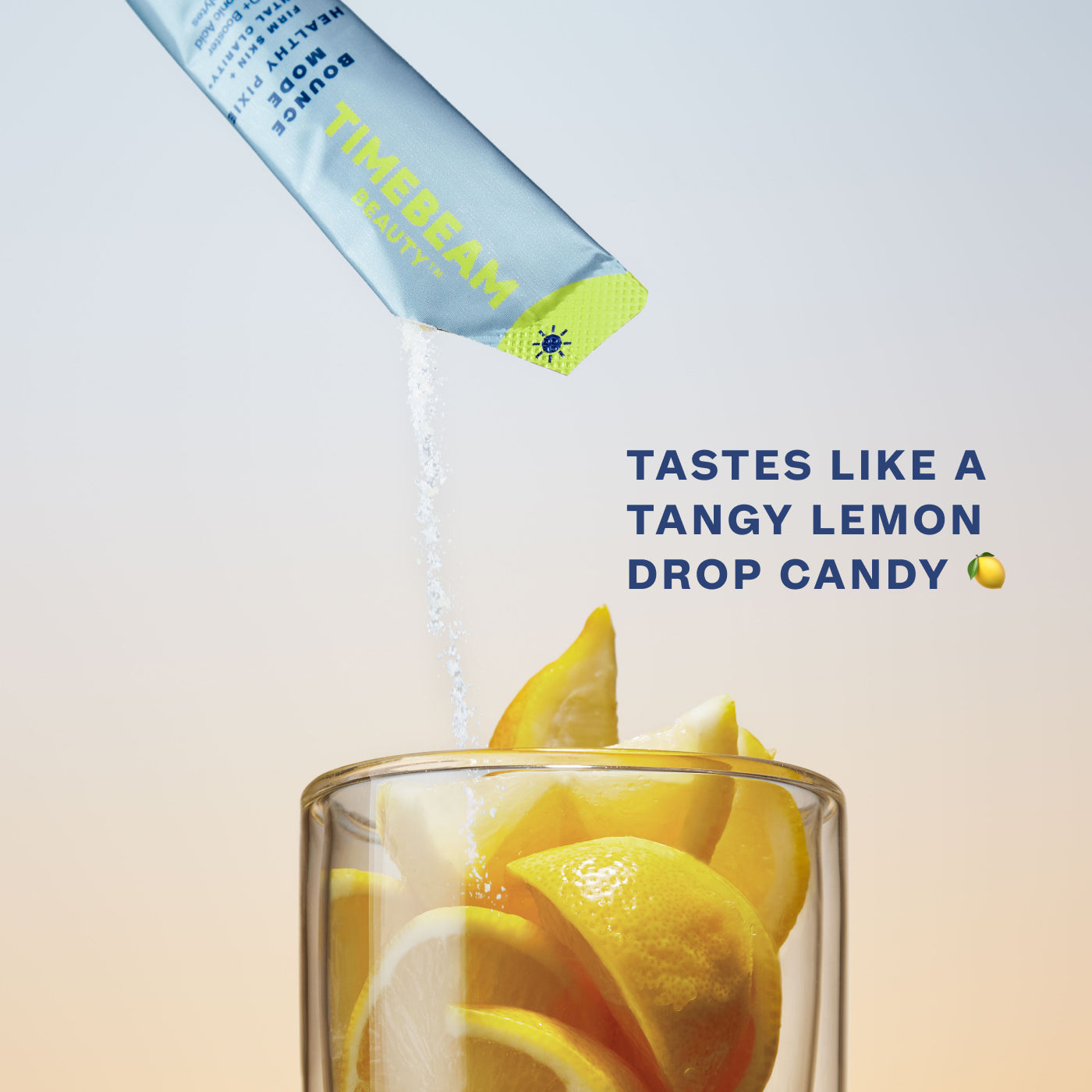 The contents of a TIMEBEAM pouch pour into a glass filled with lemon slices, with text reading "Tastes like a tangy lemon drop candy".