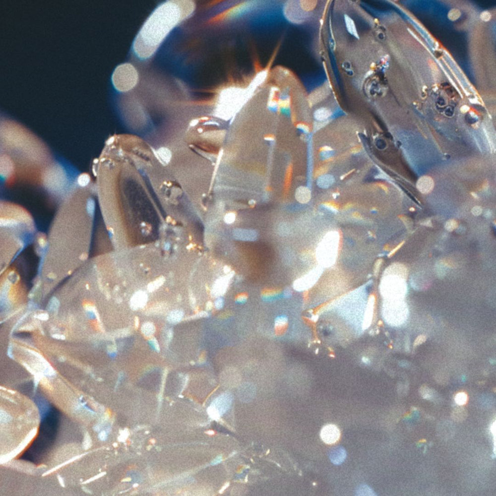 A luminous cluster of translucent, crystal-like forms resembling quartz or ice.