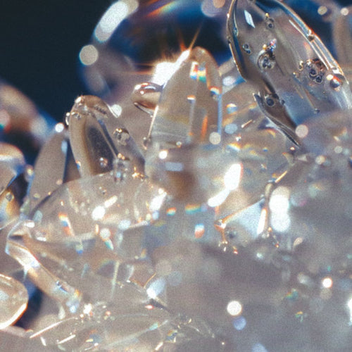 A luminous cluster of translucent, crystal-like forms resembling quartz or ice.