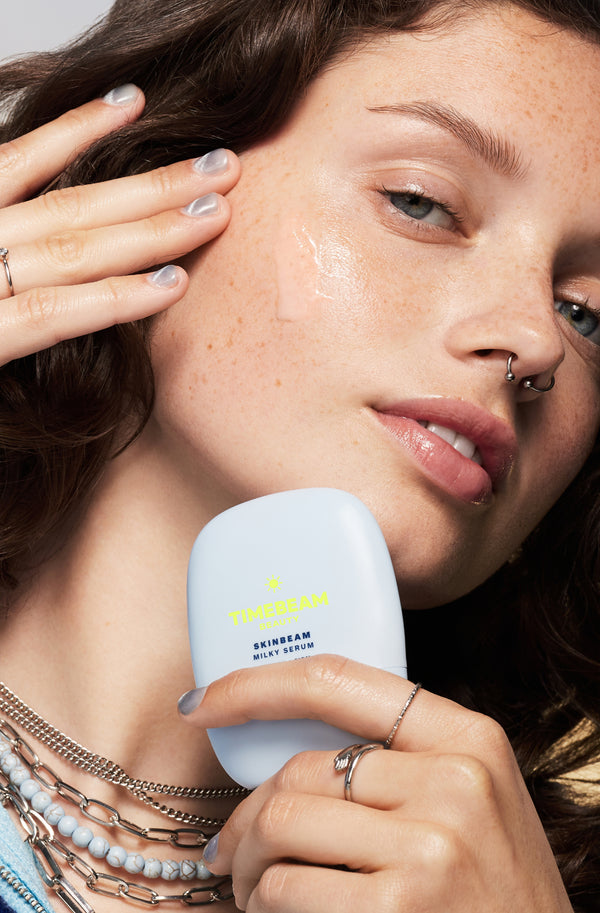 A woman applying TIMEBEAM Skinbeam silky serum.
