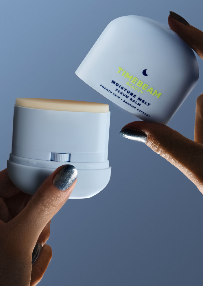 Two hands holding an open bottle of TIMEBEAM Moisture Melt Balm.