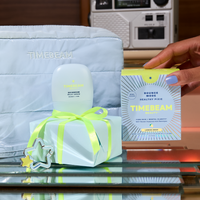 Timebeam skincare product with packaging on a reflective surface, with a hand and vintage radio in the background.