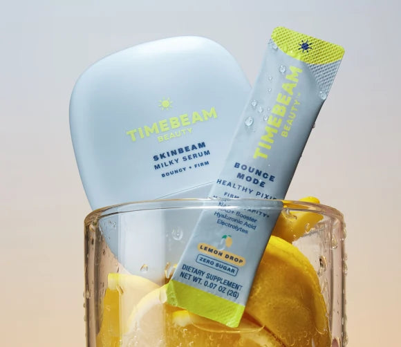 TIMEBEAM Milky Serum and a Bounce Mode supplement pouch in a glass with lemons.