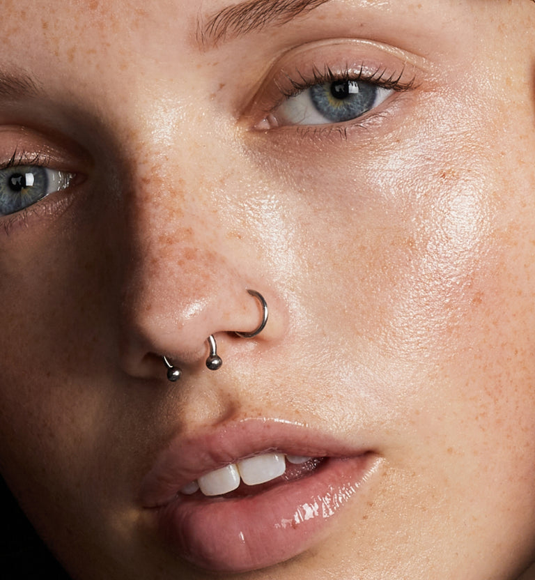 Close-up of a woman's makeup-free face, with a shiny glow.