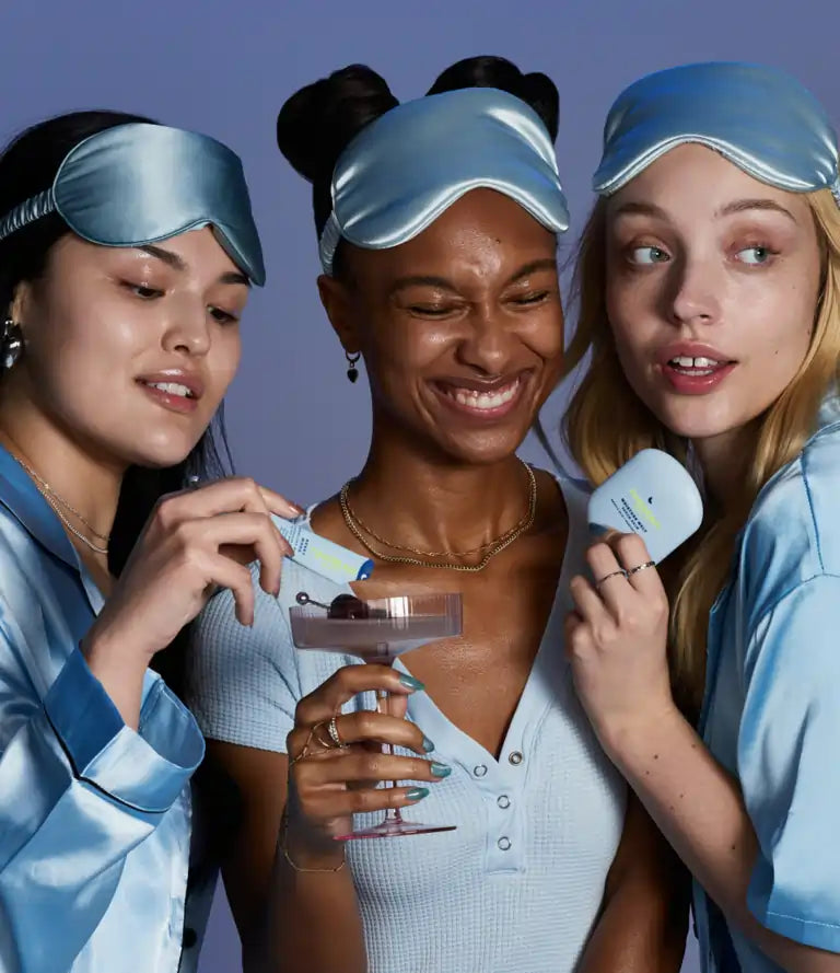 Three smiling women with sleeping masks on their heads, making a TIMEBEAM supplement drink and holding a TIMEBEAM balm.