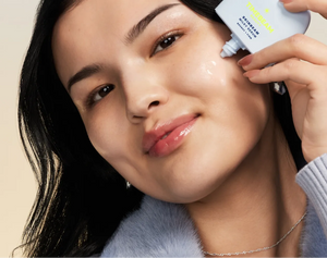 A woman applying TIMEBEAM Milky Serum to her face.